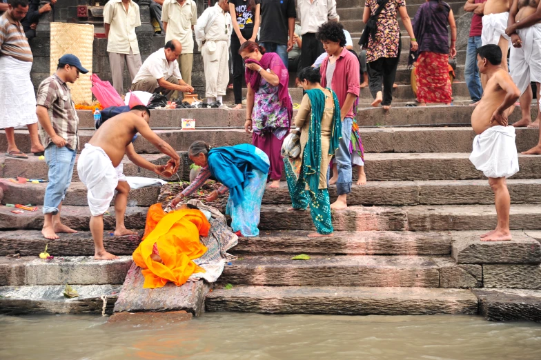 a group of people standing and standing near a body of water