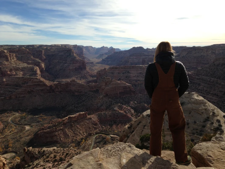 person on top of a cliff looking down over an open canyon