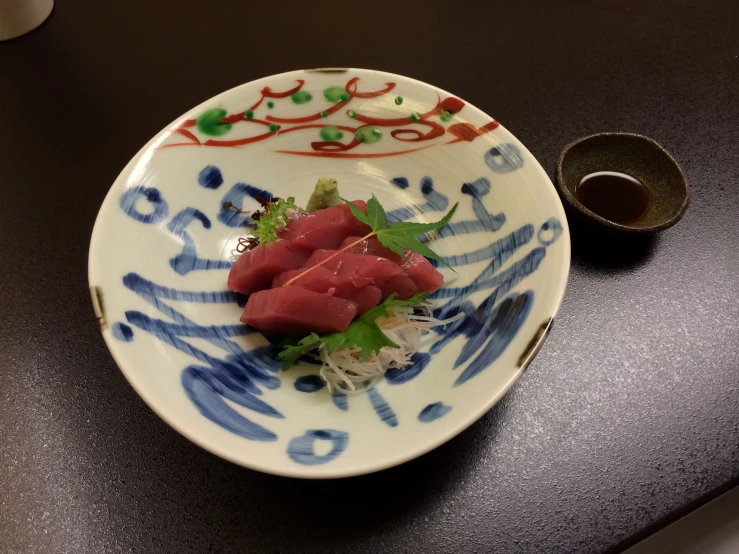 a dish with a few pieces of tuna and sauce