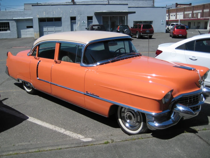 an orange classic car parked in a parking lot