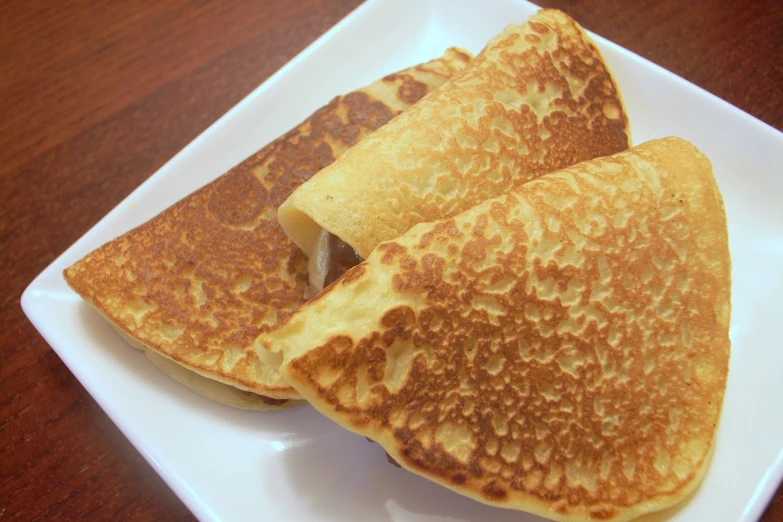 three pancakes that are on a white plate