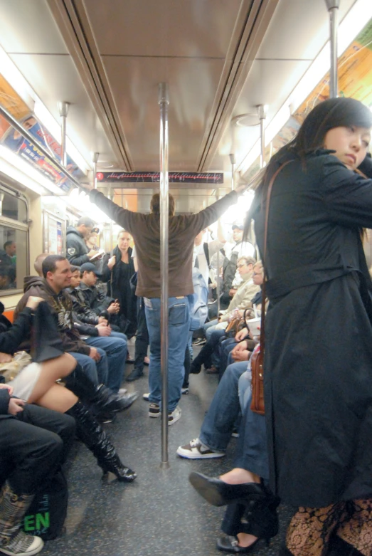 the crowded metro car is full of people