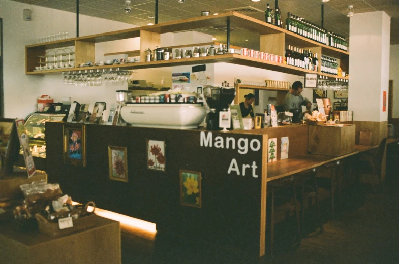 a man behind the counter of a restaurant with alcohol on it