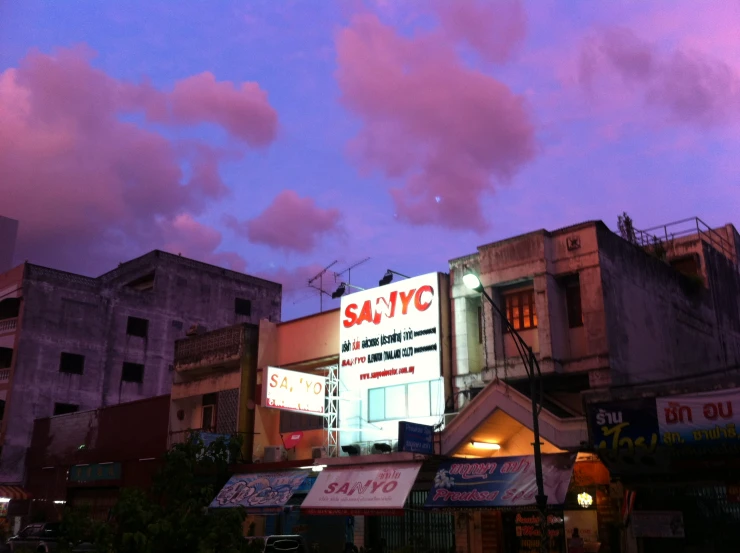 some buildings at dusk with a pink sky