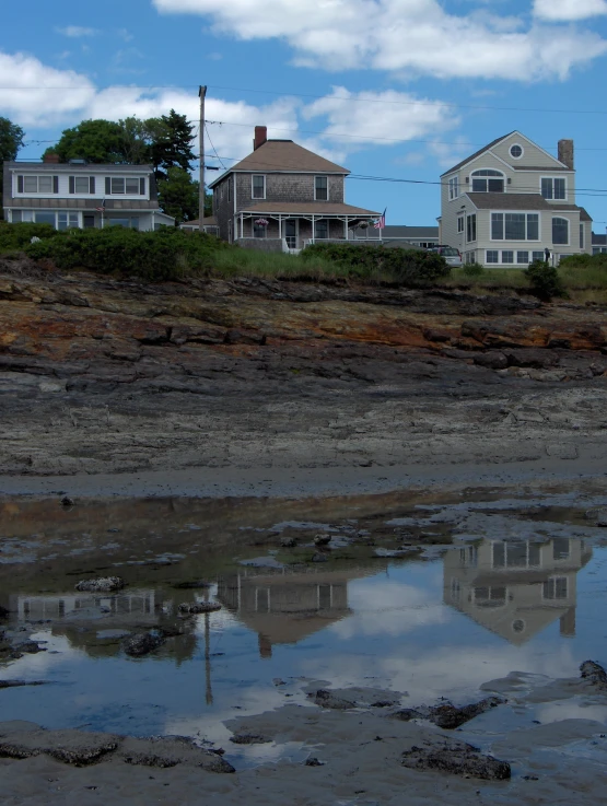 a house is shown near the water on the shore