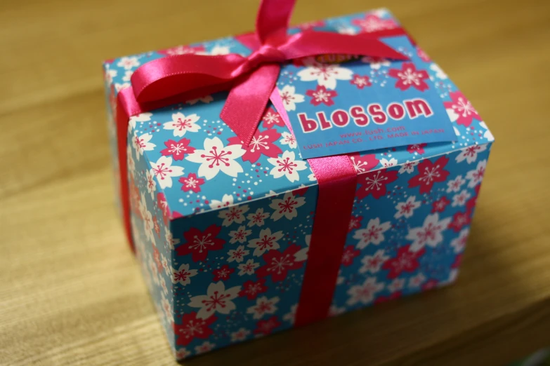 a blue and pink package tied with red ribbon