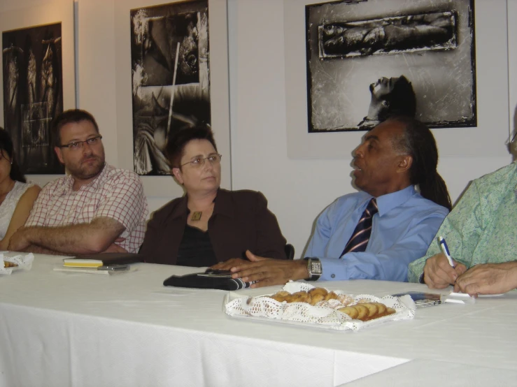 a group of people sitting at a table in front of pictures