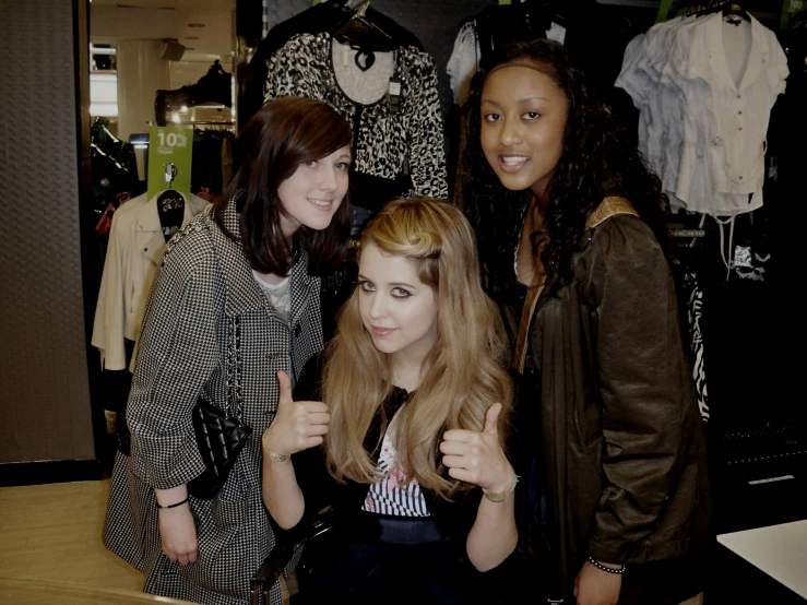 three women standing together at a clothing store