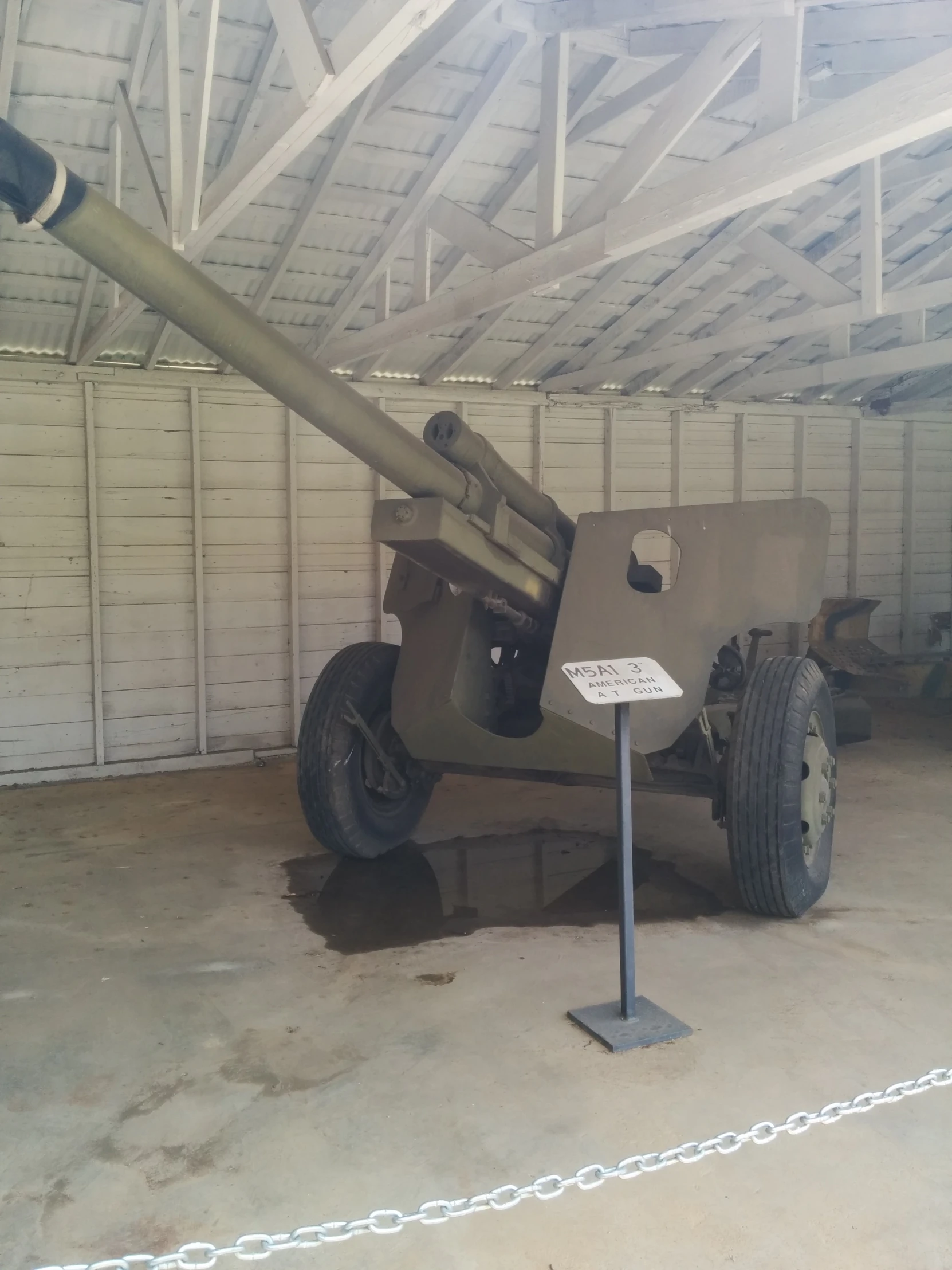 an old, rusted, heavy - duty, gun is in the garage