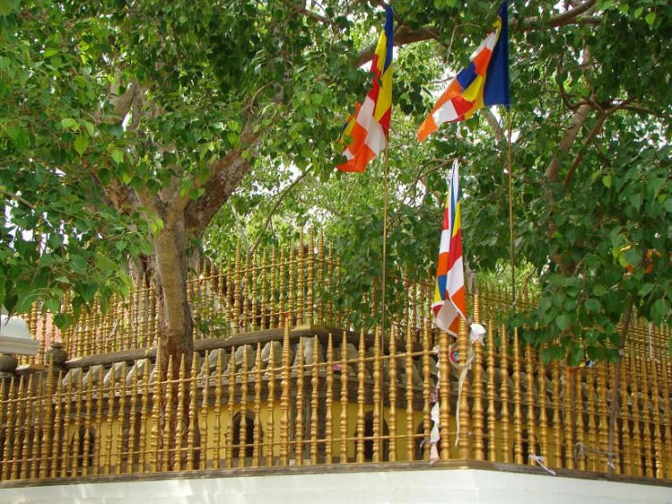 a wooden fence with many flags hanging from it