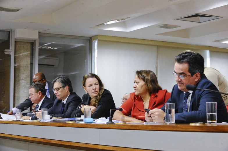 a group of people sitting at a table in a meeting