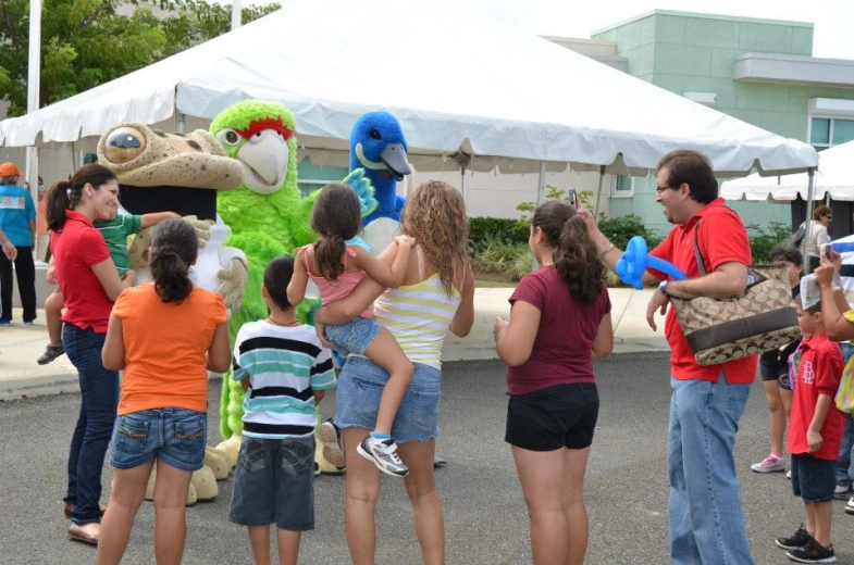 several people gathered in front of a large mascot