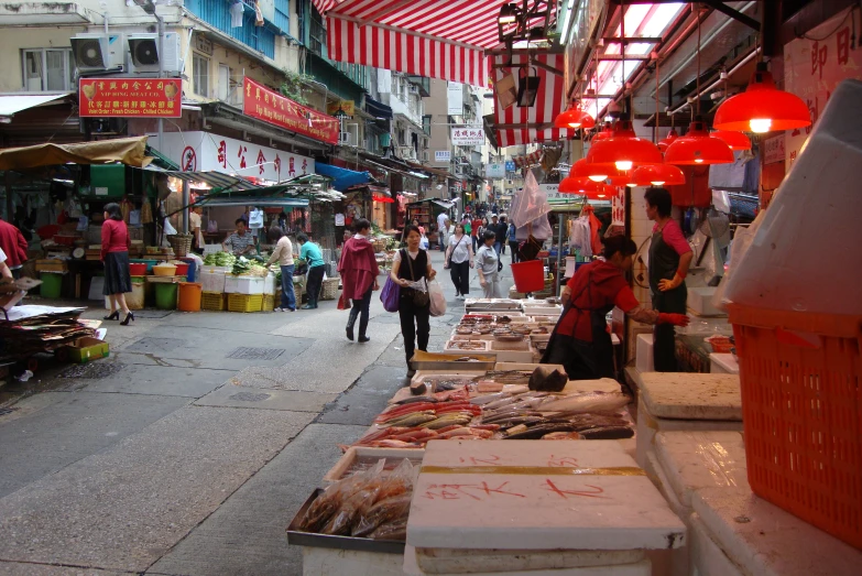 people at a market with an abundance of vegetables