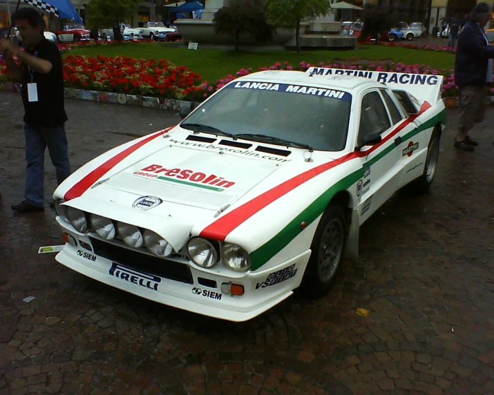 a classic race car sitting on the side of a road