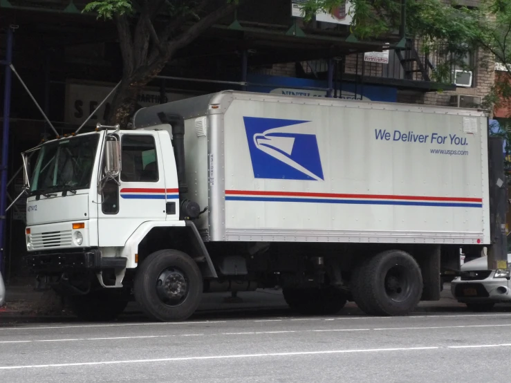 a postal truck is parked near an entrance