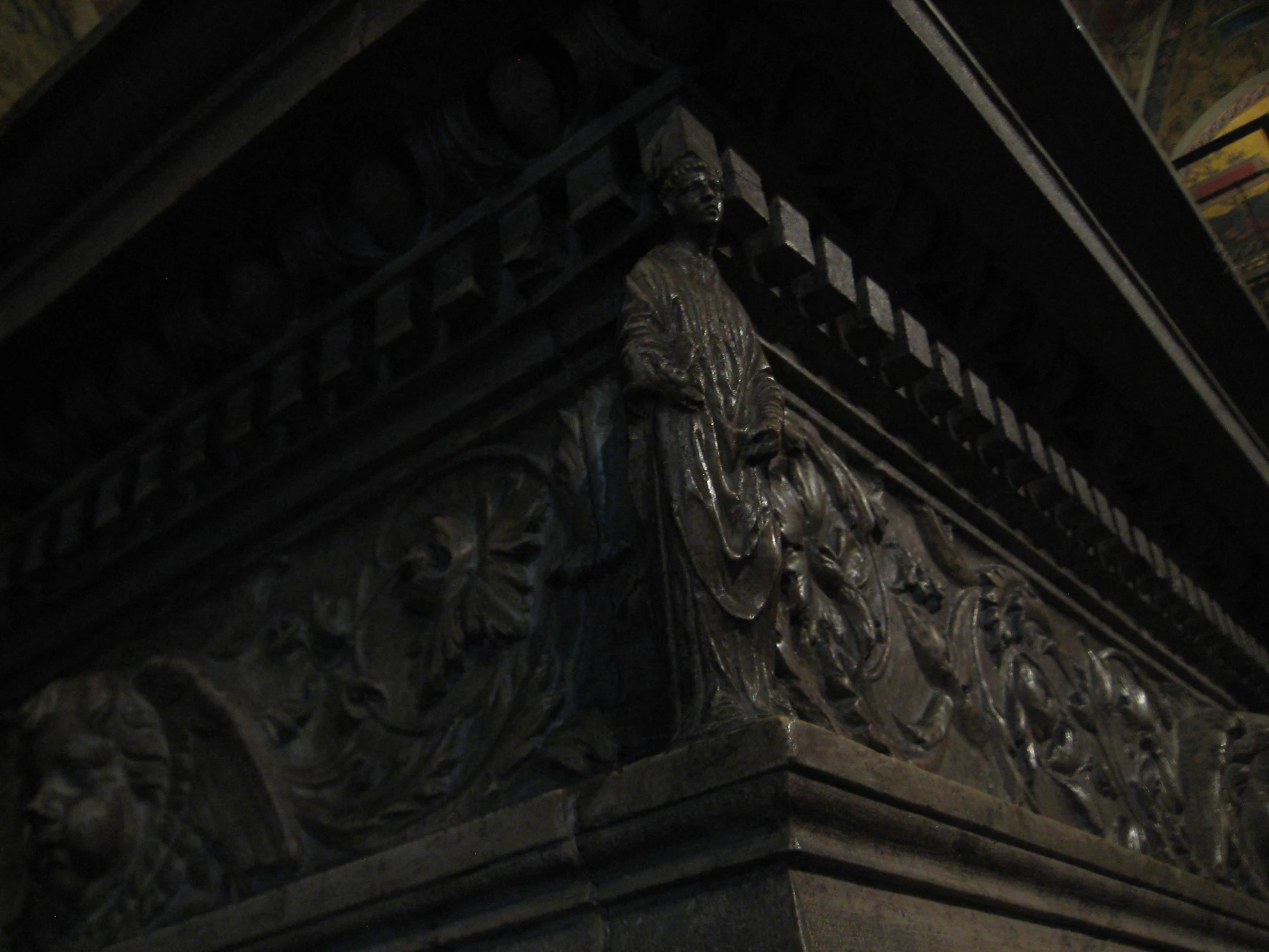 a carved pillar in a building is seen at night