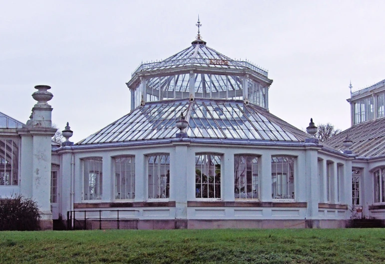 an old and antique looking building in a big grassy field