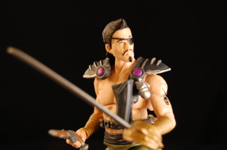 an action figure of a male wearing armor and holding swords