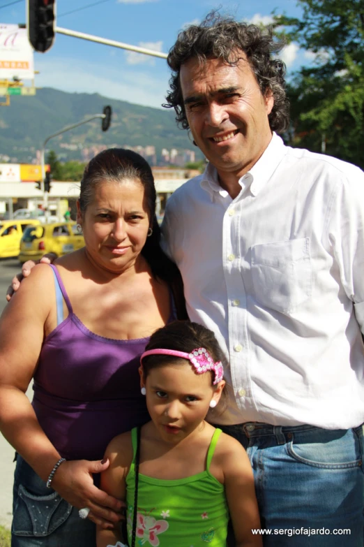 an adult with his two daughters standing beside him