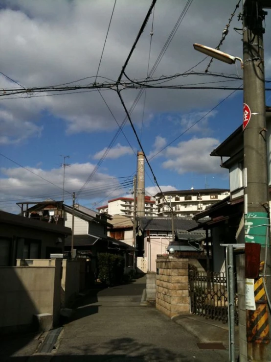 the road has power lines above houses and on the other side of the street