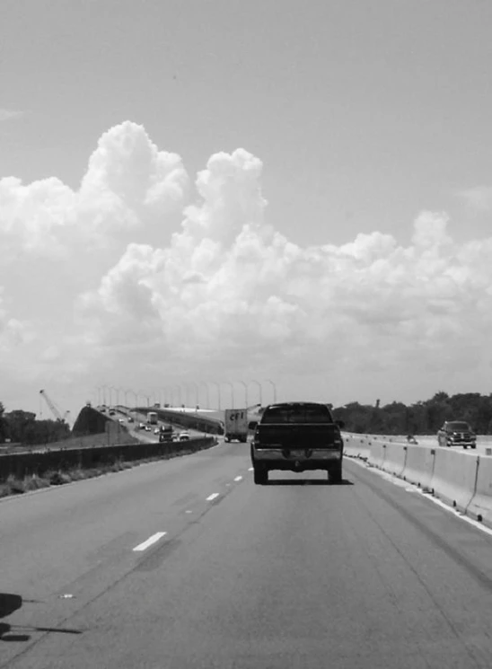 black and white pograph of cars driving down the highway