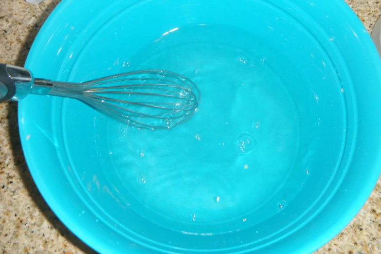 a bowl with an whisk inside, it is blue