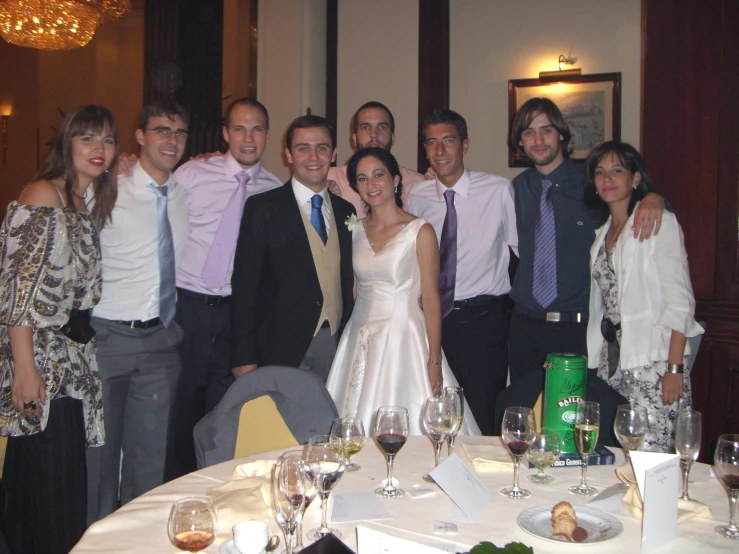 a bride and groom standing together at a formal dinner table