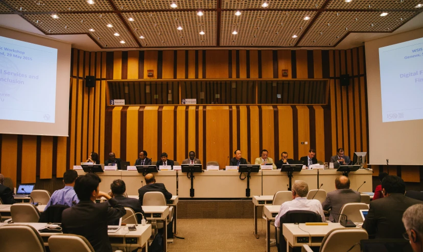 a conference room with people and projector screens