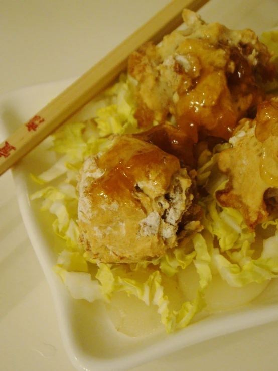 a plate topped with lots of food and two chop sticks