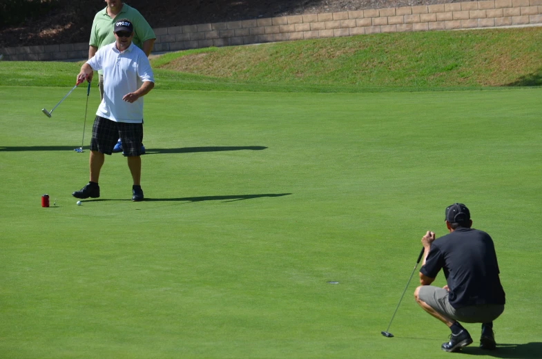 a man is playing golf in the field and is taking pictures