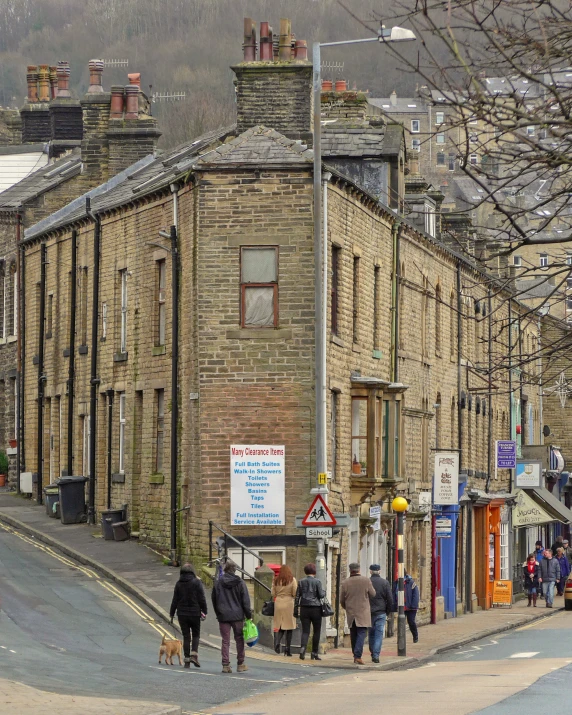 people walking on the sidewalk next to some old buildings