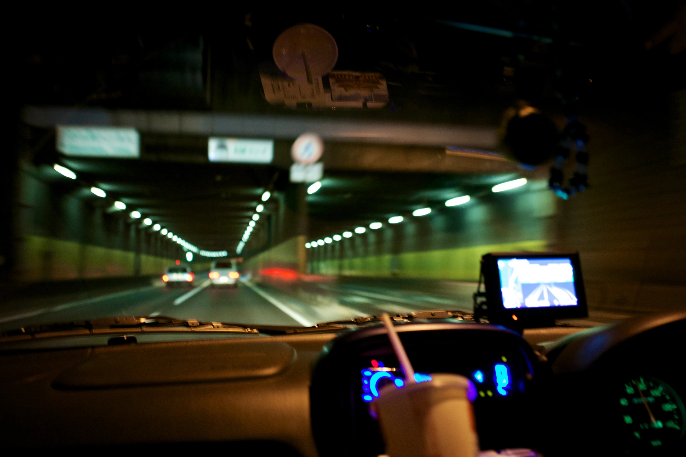 a view of an overhead highway through windshield in the dark