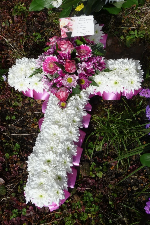 flowers and candles are laid on a cross