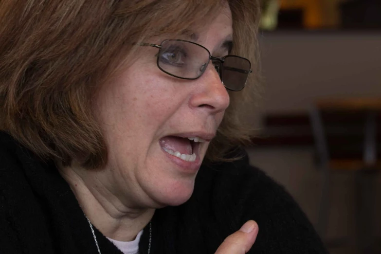 a woman wearing glasses talking on her cell phone