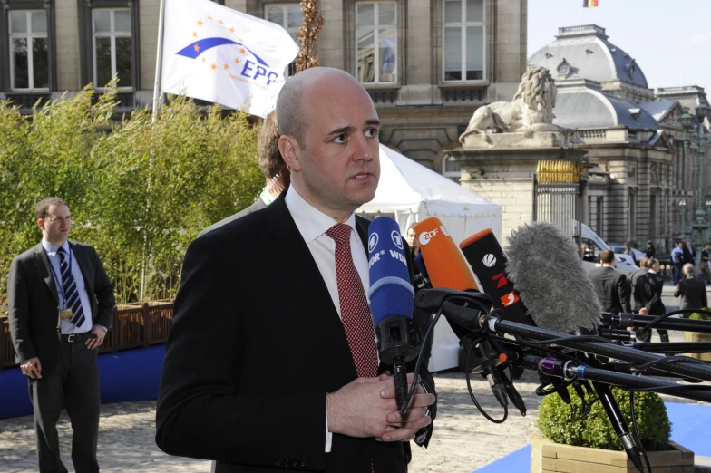 a man in a suit speaking into a microphone