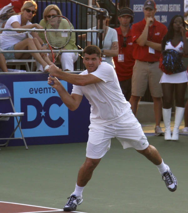 a man playing tennis in front of a crowd