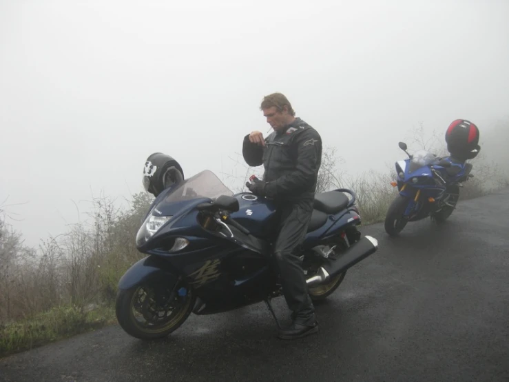 a man sitting on the back of a blue motorcycle