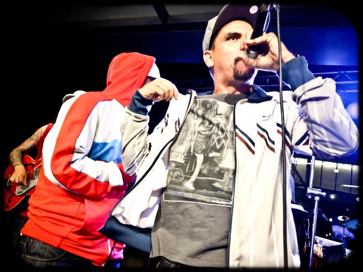 two people with hoodies and microphones standing