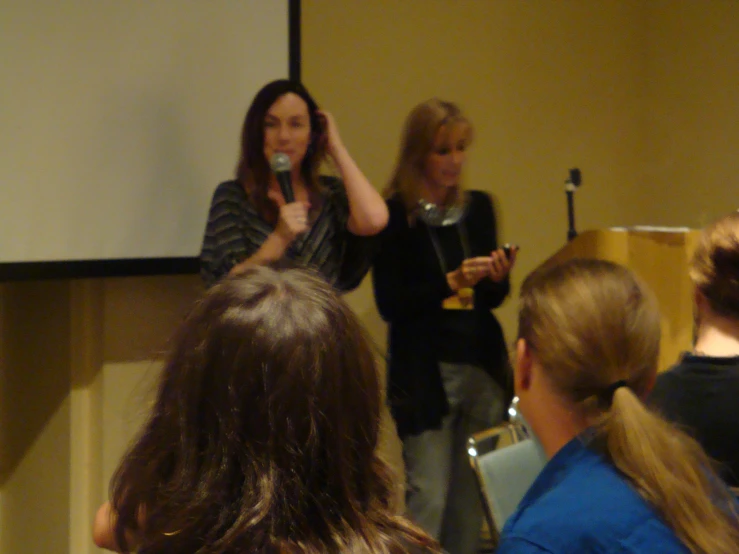 two women are giving a presentation to an audience