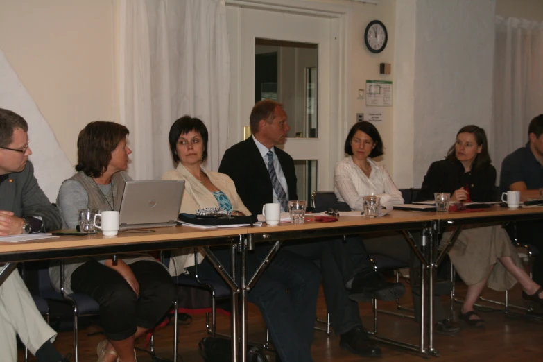 a group of people at a conference listening to speakers