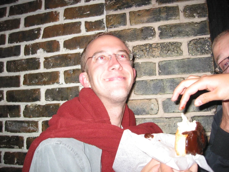 a person holding a  dog in front of a brick wall