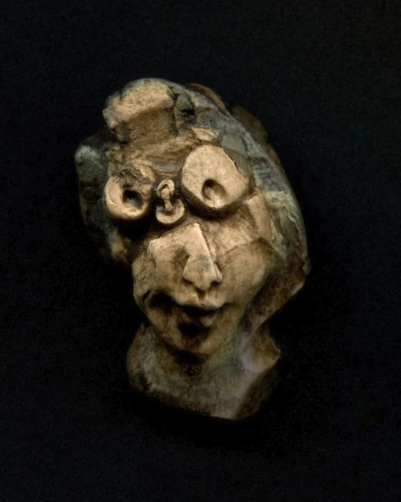 a carved stone object with two eyes and one nose