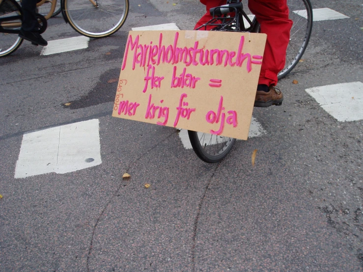 a woman on a bicycle holding up a sign