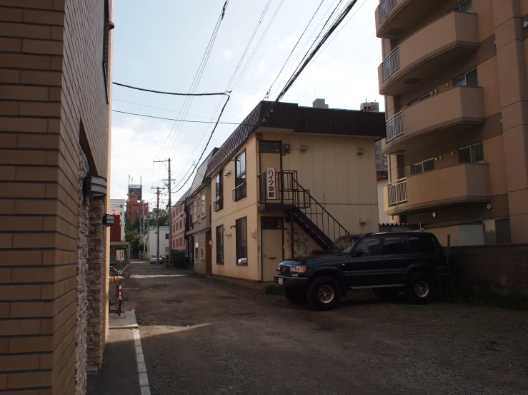 a black truck parked in front of a yellow building