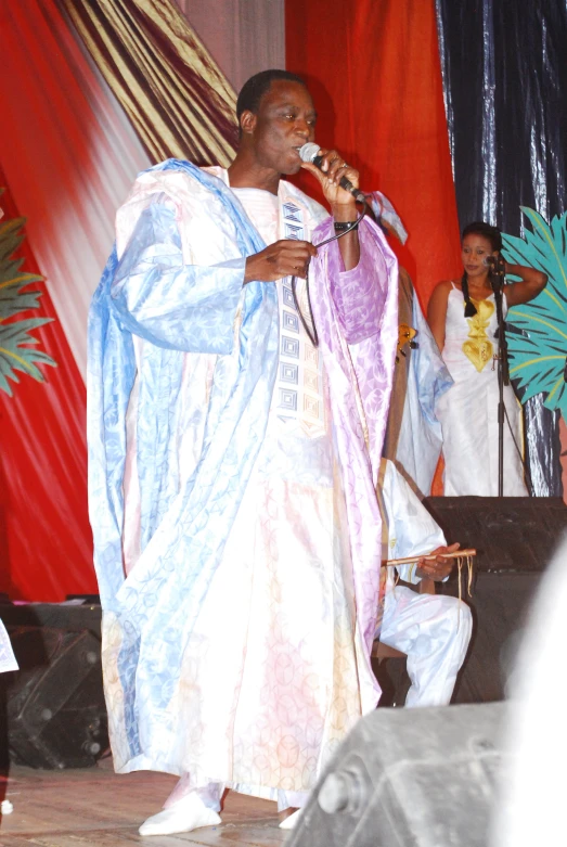 a man in a costume standing in front of a microphone