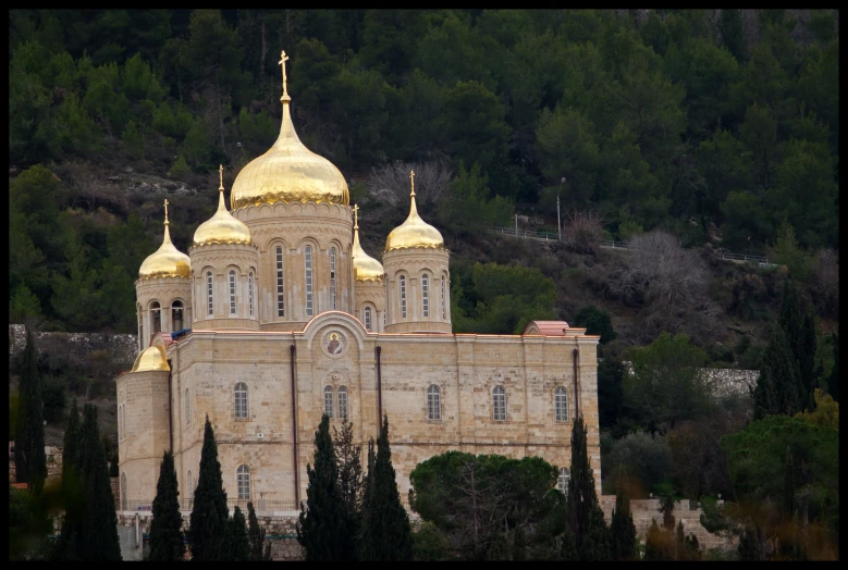 a building with gold dome and spires with trees in the background