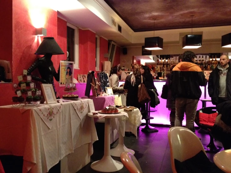 a room with tables, people and red walls