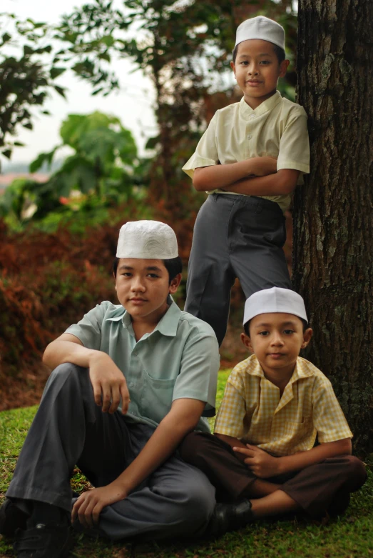 two boys and their parents standing by a tree