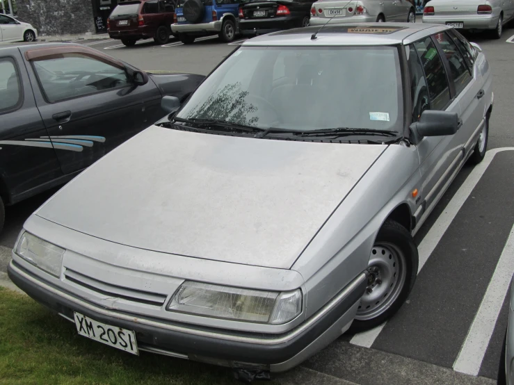 a white and grey car and cars are on the street