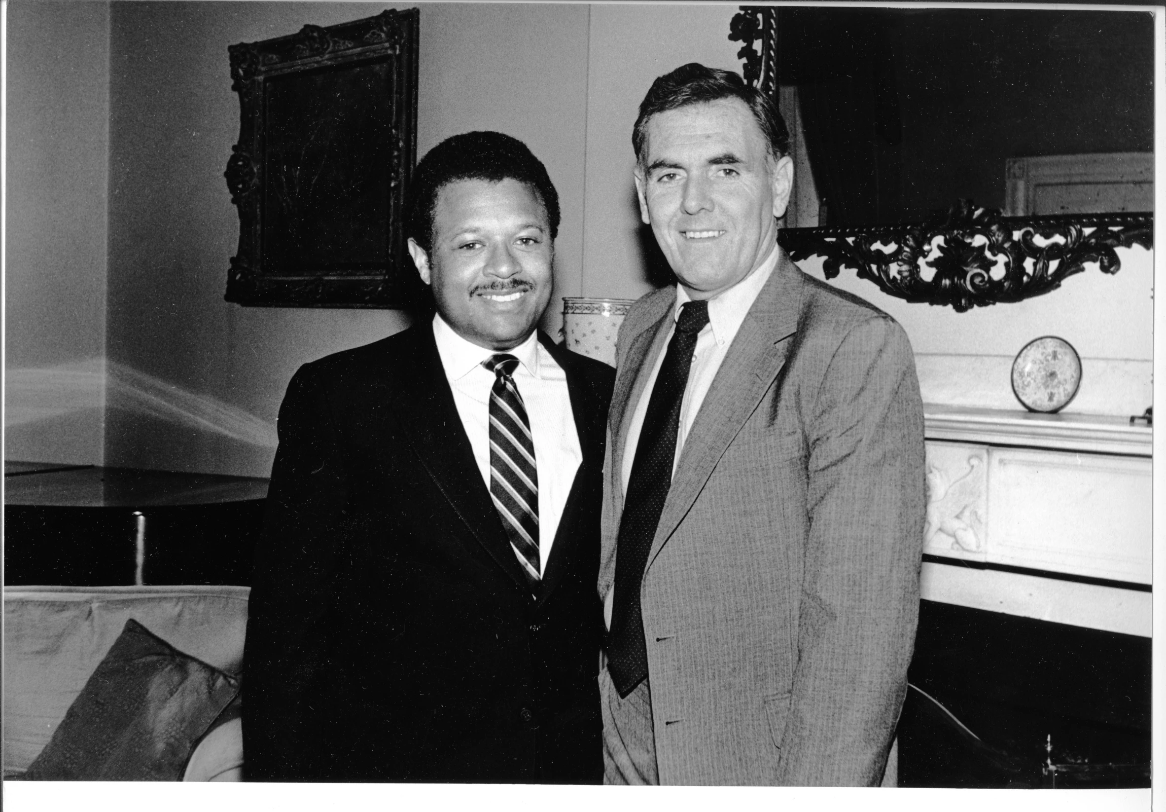 two men wearing suits standing together for a po